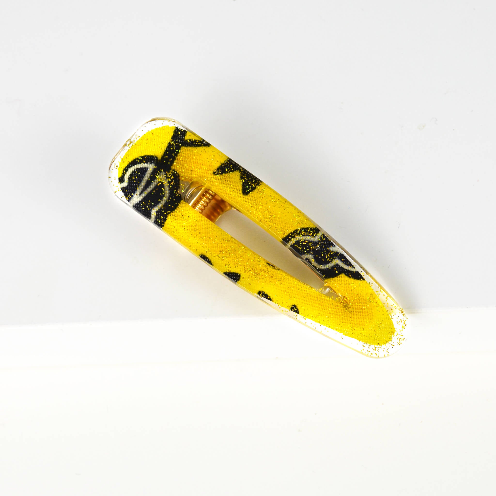 Barrette écorespondable en forme de goutte en résine recouvrant un morceau de chute de pagne wax recyclé