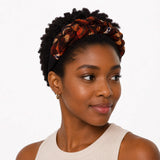 Femme noire aux cheveux crépus courts portant un serre-tête tressé rouge et brun en mousseline de soie