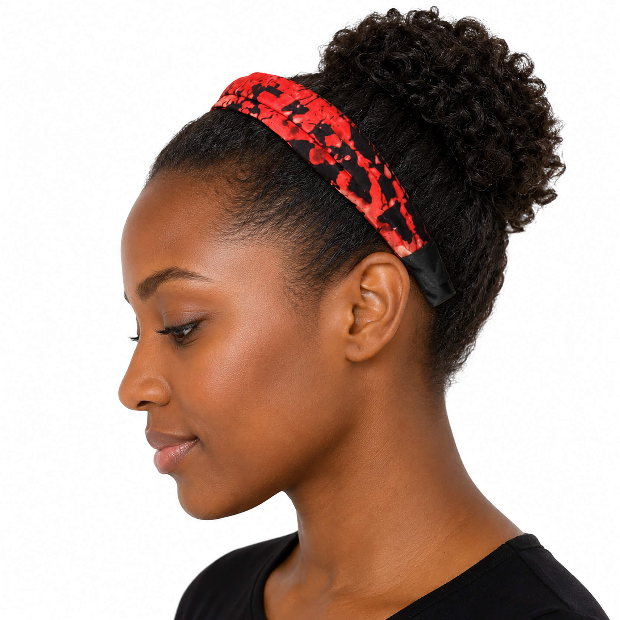 Femme noire portant un serre-tête plat rouge et noir en tissu imprimé, vue de profil sur fond blanc.