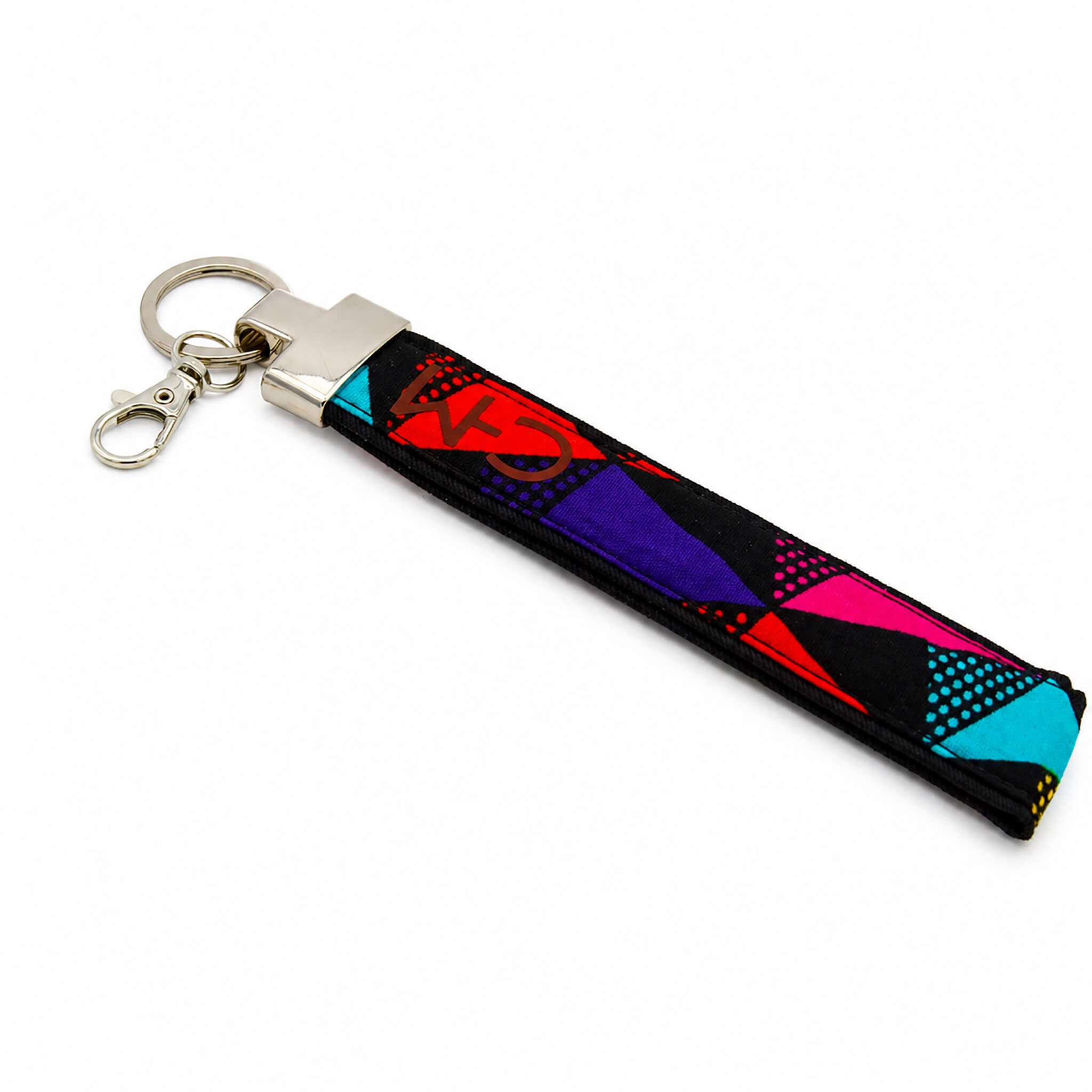 Porte-clé en pagne wax multicolore aux motifs rouges, mauves, bleus et roses sur fond blanc, vue en angle