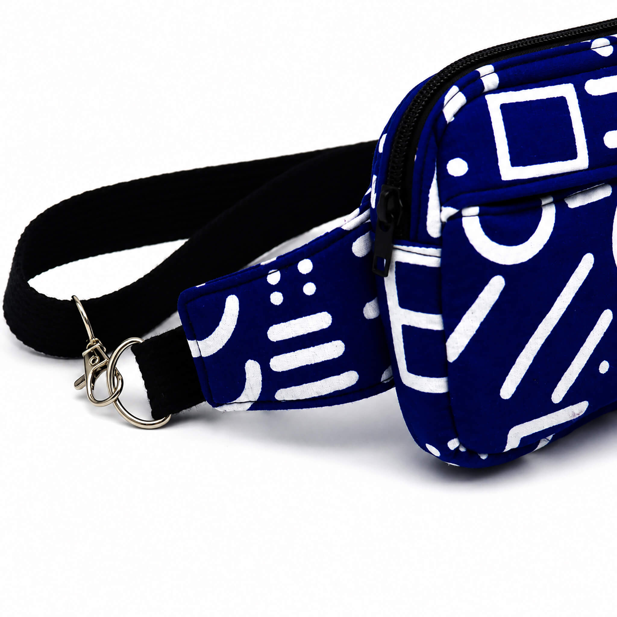 Détail du mousqueton métallique amovible du sac bandoulière convertible bleu et blanc.