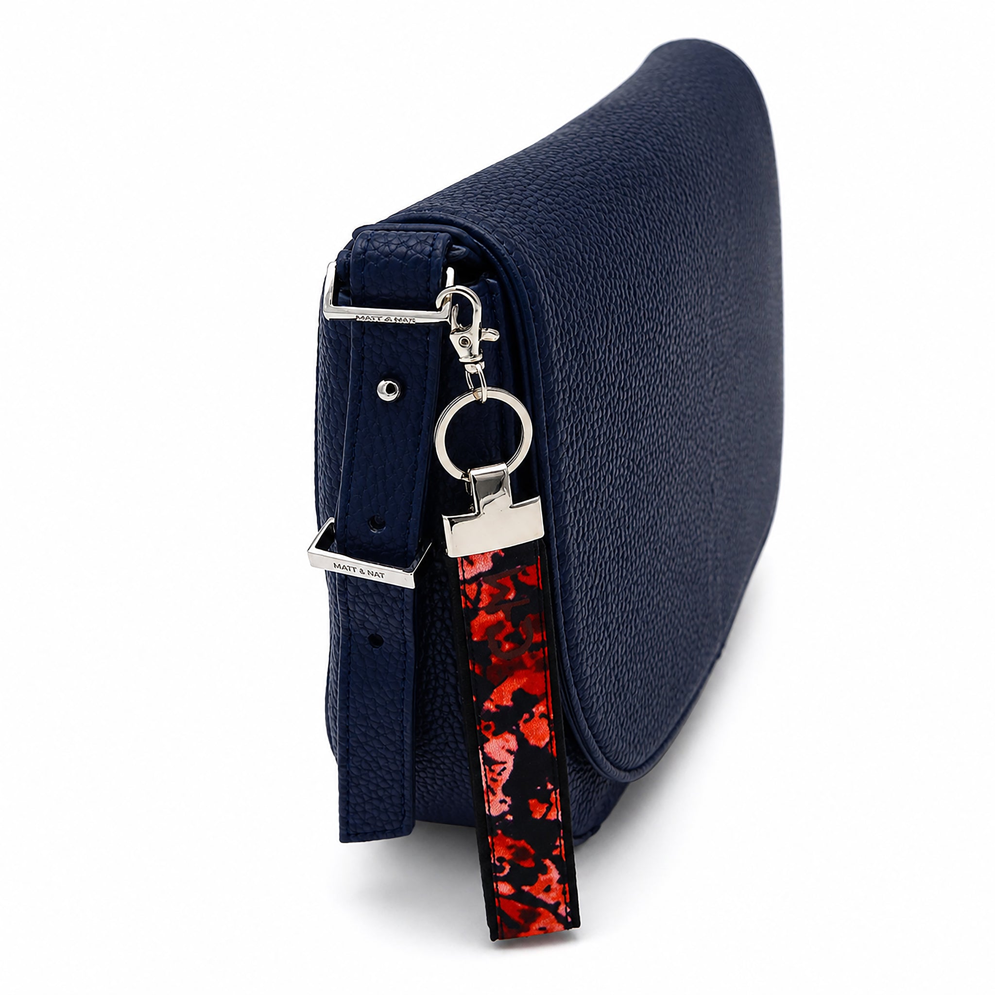 Porte-clé en tissu Coo-Mon attaché à un sac bleu marine avec mousqueton, utilisation quotidienne