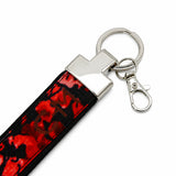 Détail du tissu du porte-clé Coo-Mon avec motif rouge et noir, finition soignée