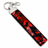 Porte-clé en tissu rouge et noir Coo-Mon avec anneau et mousqueton sur fond blanc