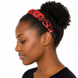 Femme noire portant un serre-tête plat rouge et noir en tissu imprimé, vue de profil sur fond blanc.