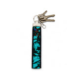 Porte-clé en tissu turquoise et noir avec clés attachées sur fond blanc