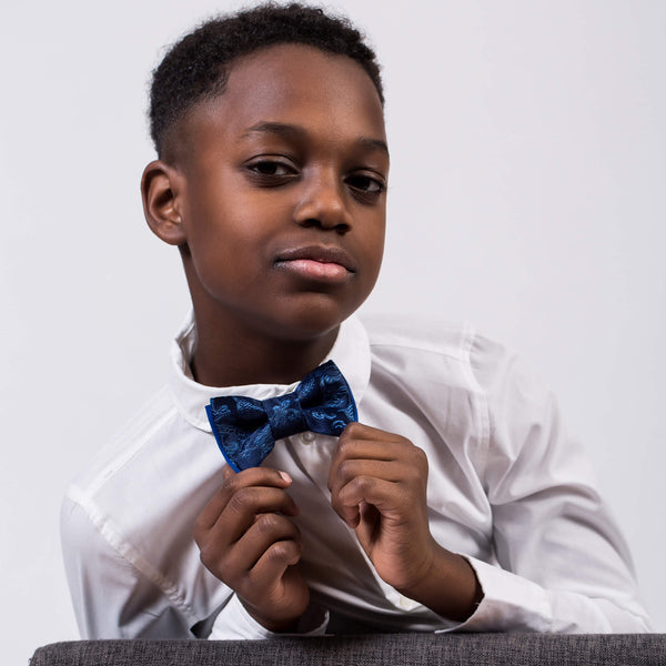 black boy with white shirt wearing navy blue bow tie